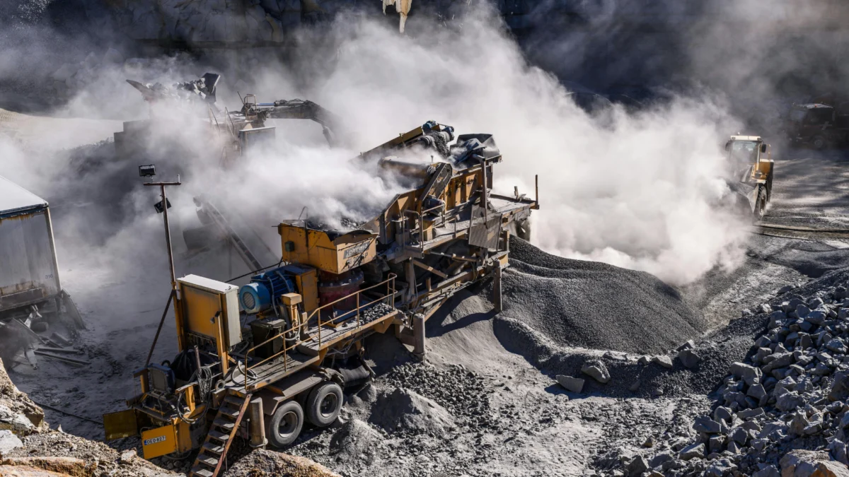 Britador móvel em operação de processamento mineral em uma pedreira. A imagem ilustra a fase operacional que necessita de licenciamento mineral e acompanhamento técnico de uma consultoria geológica para garantir a conformidade ambiental e produtividade.